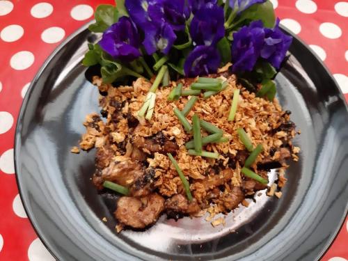 Un plato de comida en una mesa con flores moradas. en Activities Resort, en Ko Yao Yai