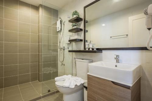 a bathroom with a sink and a toilet and a mirror at Courtyard khaoyai by JP in Mu Si