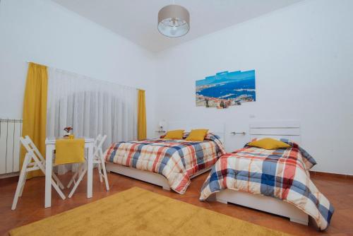 um quarto com duas camas e uma mesa e uma mesa em Naporà em Nápoles