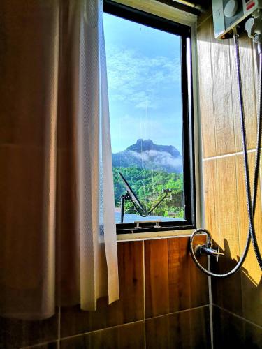 a bathroom window with a view of a mountain at Him doy muang pan resort ฮิมดอยเมืองปานรีสอร์ท in Ban Sop Pan