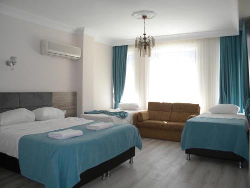 Habitación de hotel con 2 camas y sofá en Sava Hotel en Antalya