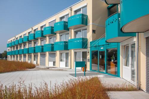 a building with blue balconies on the side of it at Victory Gästehaus Therme Erding in Erding