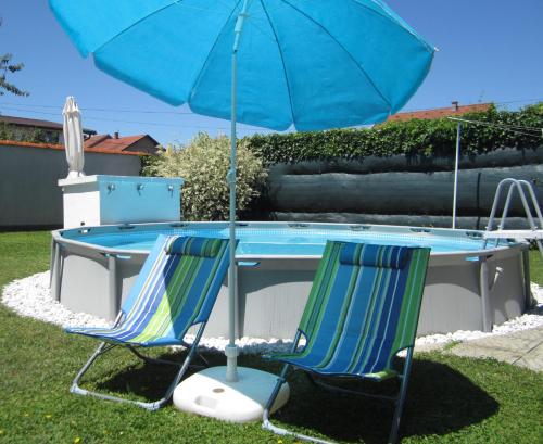 a table with two chairs and an umbrella at Apartman TIM in Osijek