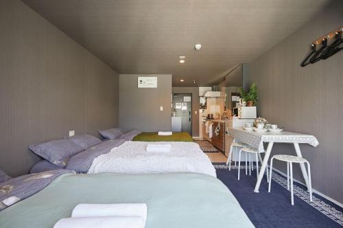 1 dormitorio con cama, mesa y cocina en Akabane TK Building 302, en Tokio