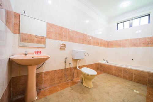 Kampong Raja的住宿－OYO 44033 Terap Inn Kuala Nerang，浴室配有卫生间、盥洗盆和浴缸。