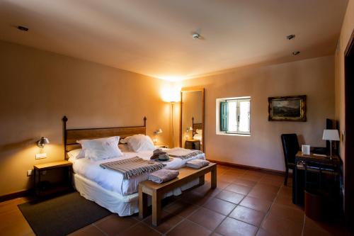 a bedroom with a large bed and a table at Hacienda Zorita Wine Hotel & Spa in Valverdón