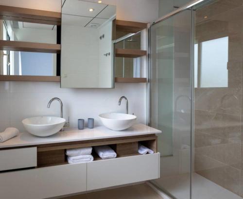 baño con 2 lavabos y ducha de cristal en Encantador apartamento con piscina y AC - Helgafell 126, en Ciudad Quesada