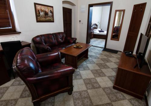 a living room with a leather couch and a table at Pension Horse Inn in Košice