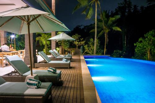 Ubud Hills Villas & Resort في أوبود: وجود مسبح وكراسي الصالة والمظلات بجواره