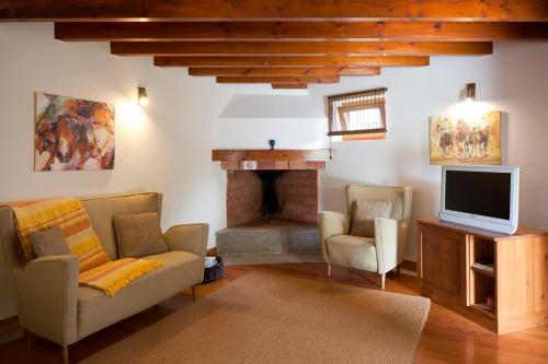 a living room with a tv and a fireplace at Solar Do Magoito in Sintra