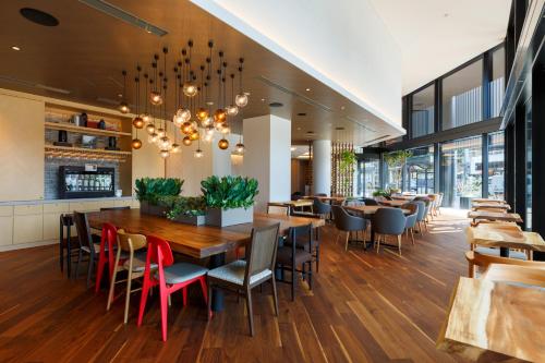a restaurant with a large wooden table and chairs at Hotel Forza Kanazawa in Kanazawa