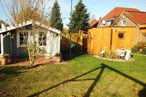 a yard with a house and a fence at Ferienwohnung Nordbrock, 65317 in Moormerland