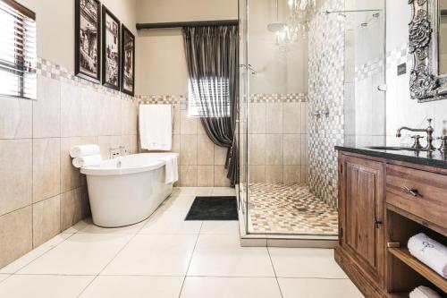 ein Bad mit einer Badewanne, einer Dusche und einem Waschbecken in der Unterkunft Tramonto Boutique Hotel in Newcastle