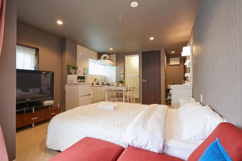 a bedroom with a white bed and a red couch at Akabane TK Building 303 in Tokyo