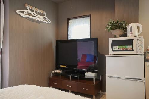 a living room with a television and a microwave at Akabane TK Building 303 in Tokyo