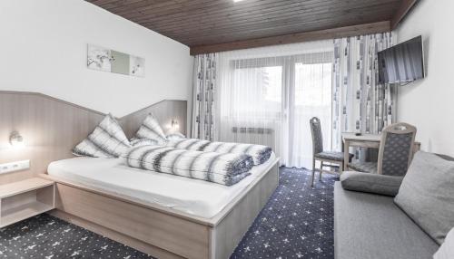 1 dormitorio con cama, escritorio y silla en Gästeheim Schmiedhof, en Sölden