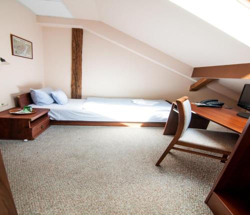 a bedroom with a bed and a desk and a chair at Pension Horse Inn in Košice