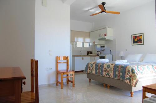 a bedroom with a bed and a ceiling fan at Odyssia Apartments in Katelios