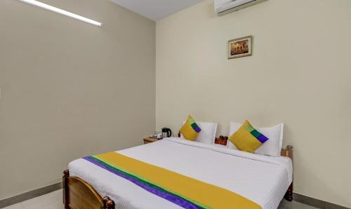 a white room with a bed with rainbow pillows at Itsy Hotels Shree Comforts in Bengaluru