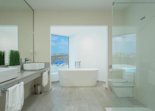 uma casa de banho branca com 2 lavatórios e uma banheira em The view lanzarote em Mácher