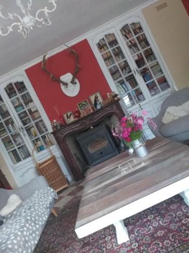 a living room with a table and a fireplace at Chez Celine et Philippe Chambre atelier dans propriété de charme avec piscine in Le Fossat