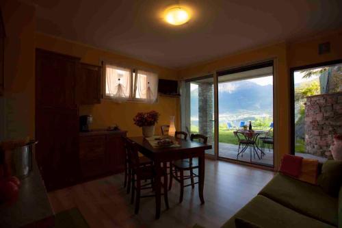 a kitchen with a table and chairs and a dining room at La Collina dei Fiori in Vercana