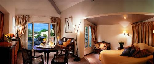 a room with a bed and a table and a room with a bed at Hotel Le Maquis in Porticcio