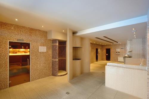 a large room with tile walls and a kitchen at Sana Spa Hotel in Hisarya