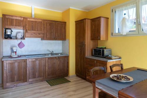 a kitchen with wooden cabinets and a table and a microwave at La Collina dei Fiori in Vercana