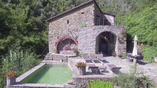a small stone building with a pool of water at Old Mill in Pigna