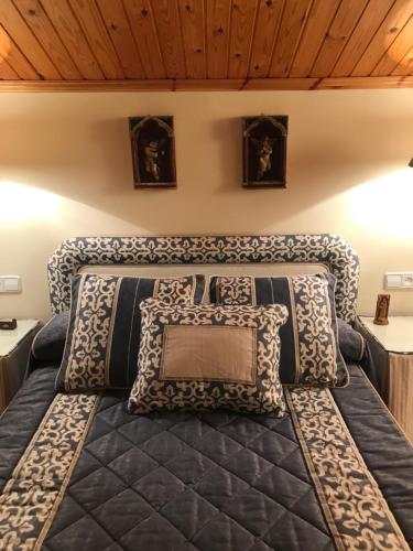 Una cama en una habitación con almohadas. en LA DEVESA, en Azanúy