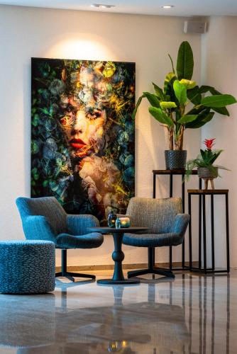 a room with two chairs and a painting on the wall at Sanadome Hotel & Spa Nijmegen in Nijmegen