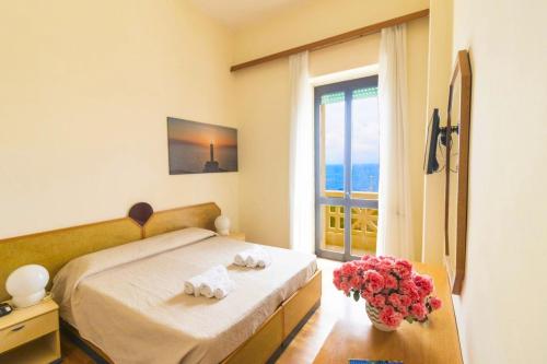 a bedroom with a bed and a vase of flowers at Albergo Palazzo in Santa Cesarea Terme