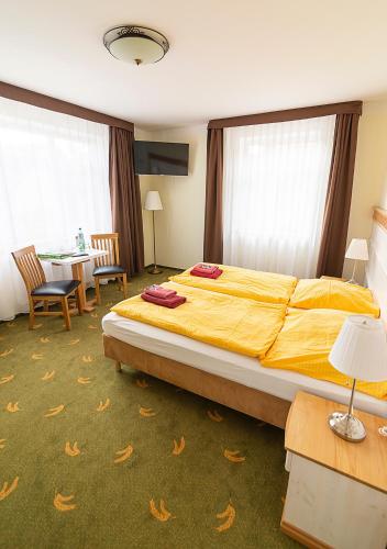 a bedroom with a large bed and a table and chairs at Gästehaus Alte Bäckerei in Dachwig