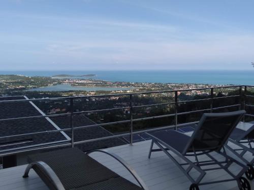 two chairs on a balcony with a view of the ocean at Perfect Sea View Mountain Villa Koh Samui in Chaweng