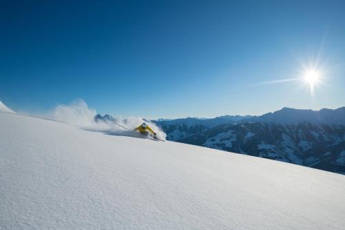 a person is skiing down a snow covered slope at Hotel Alpina in Rauris