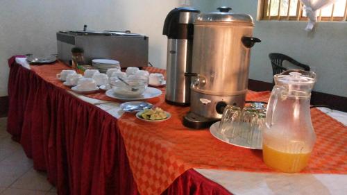una mesa con comida y bebidas en un mantel rojo en DaysInn Hotel en Lira