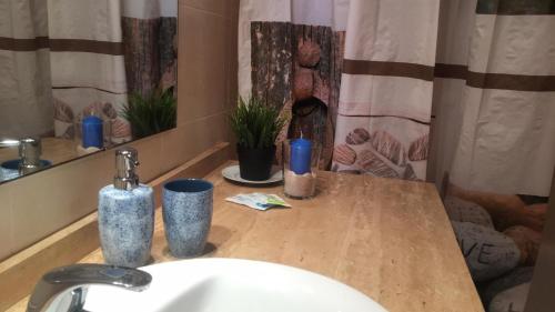 eine Badezimmertheke mit einem Waschbecken und einem Spiegel in der Unterkunft Bea Laguna Beach Vera Playa - Gratis Jacuzzi in Vera