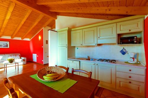 a kitchen with a table with a bowl of bananas on it at La Collina degli Ulivi in Vercana