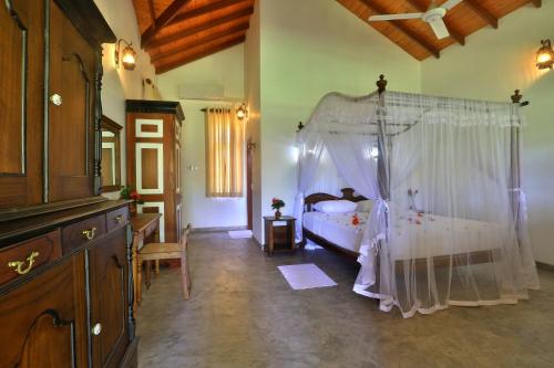 a bedroom with a bed with a canopy at Sandali Walauwa in Bentota