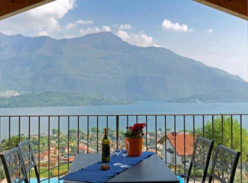 a table with wine glasses on a balcony with a view of a mountain at La Collina degli Ulivi in Vercana