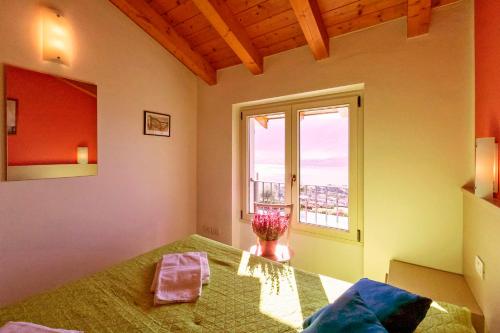 a bedroom with a bed and a window at La Collina degli Ulivi in Vercana