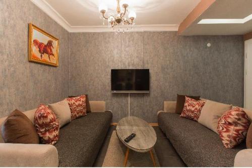 a living room with a couch and a tv at CTS Elysium Residence Taksim in Istanbul