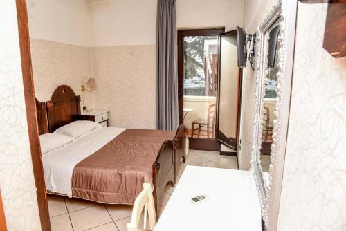 um quarto de hotel com uma cama e um espelho em Business Hotel em Casoria