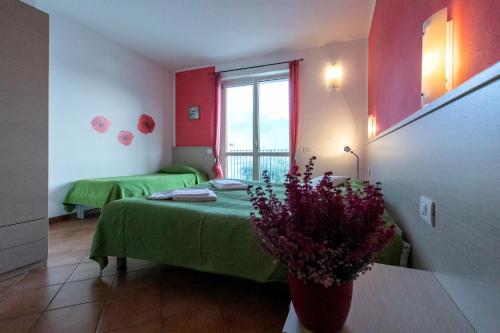 a room with two beds and a vase of flowers at La Collina degli Ulivi in Vercana
