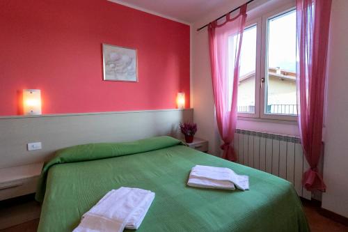 a bedroom with a green bed and a window at La Collina degli Ulivi in Vercana