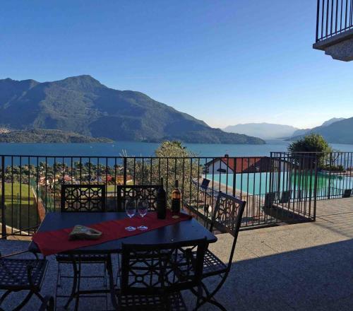 a table and chairs on a balcony with a view of a lake at La Collina degli Ulivi in Vercana