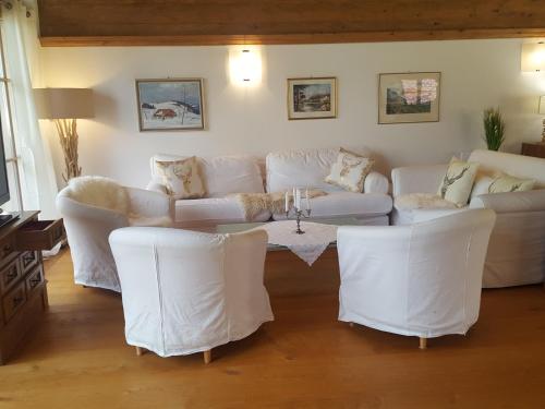 a living room with white couches and a table at LuxusChalet Happy Home Tyrol in Ellmau