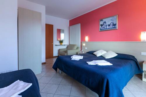 a bedroom with a blue bed with a red wall at La Collina degli Ulivi in Vercana
