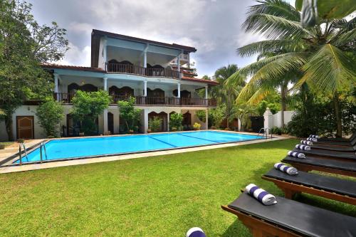 a villa with a swimming pool and a resort at Sandali Walauwa in Bentota